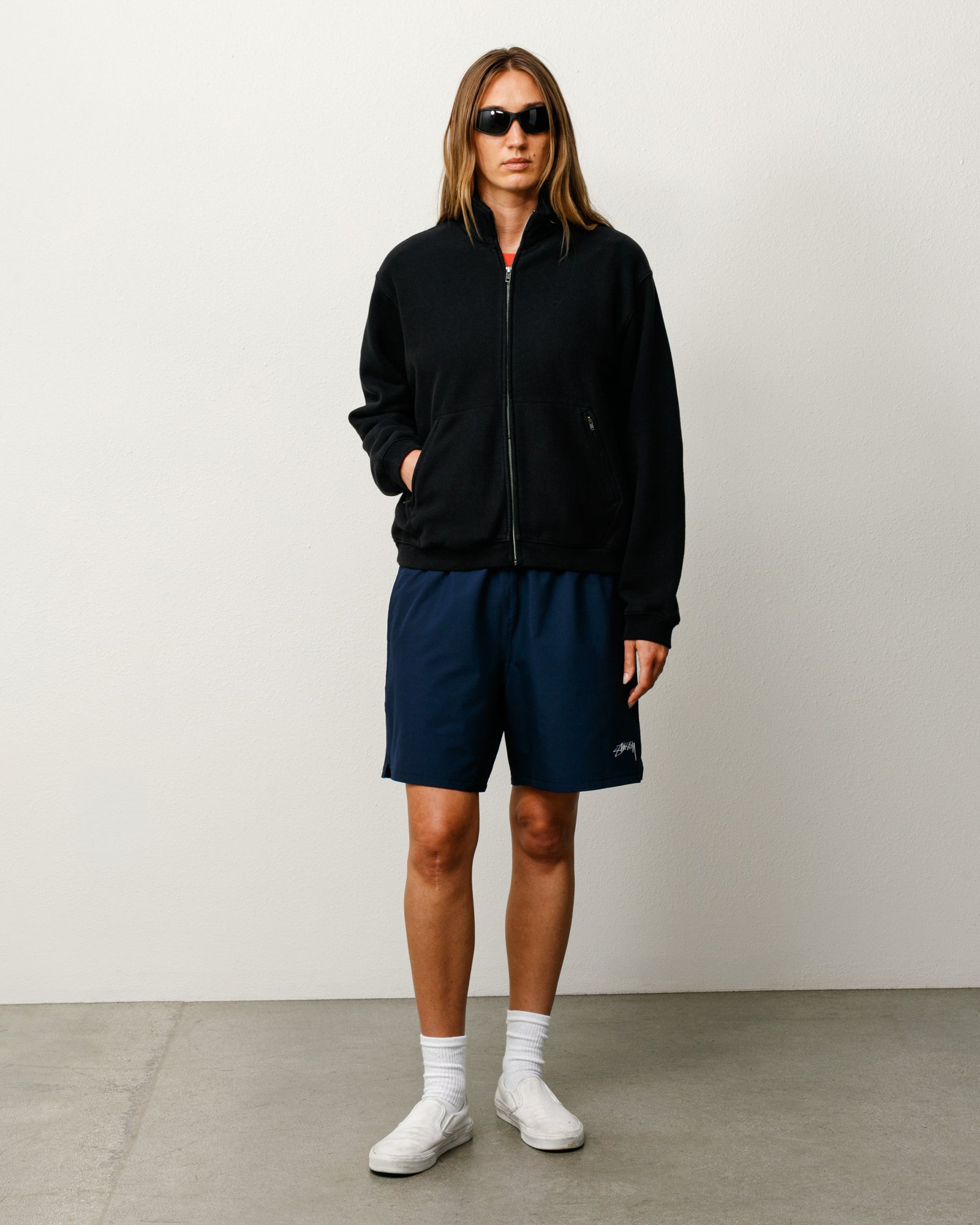 네이비 퍼포먼스 원단의 유니섹스 스포츠 쇼츠, 왼쪽 다리에 Stüssy 로고 프린트 디테일.