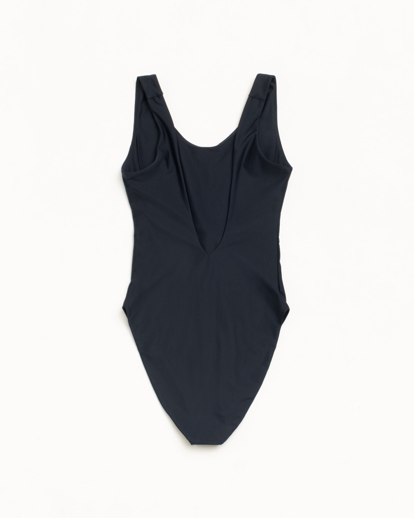 뒷면의 깊은 컷아웃 디자인과 신축성 있는 소재가 특징인 블랙 컬러의 Stüssy Surf Stock 원피스 수영복.