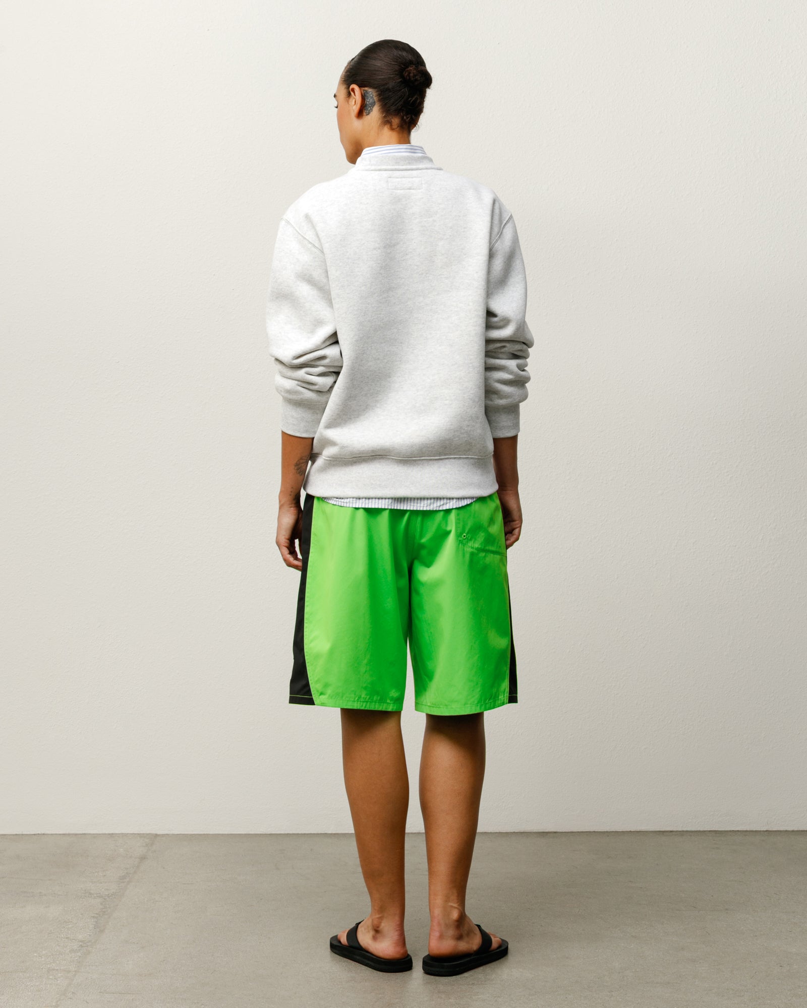 커브드 패널 보드 쇼츠 하의 그린 색상을 착용한 모델의 뒷모습으로, Stüssy 고유의 패널 디자인과 편안한 실루엣이 돋보이는 스타일입니다.