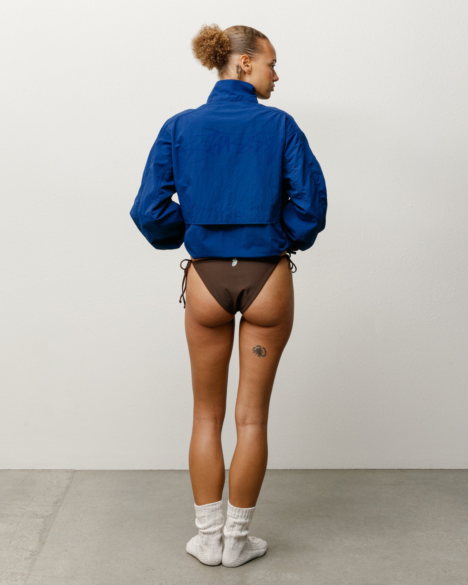 브라운 컬러의 Stüssy 여성용 레귤러 사이드 타이 비키니 하의는 뒷면의 시그니처 로고 프린트와 이중 레이어 소재가 특징입니다.