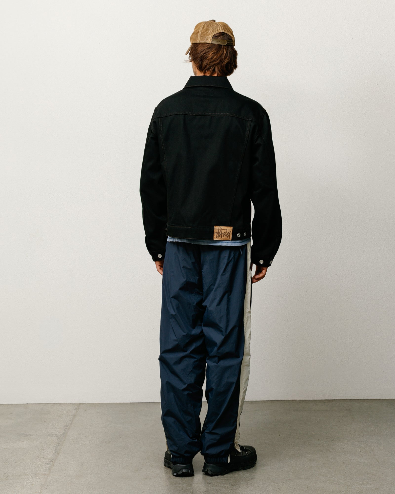 Stüssy 데님 트러커 재킷, 로 블랙 컬러에 콘트라스트 스티치 디테일 처리