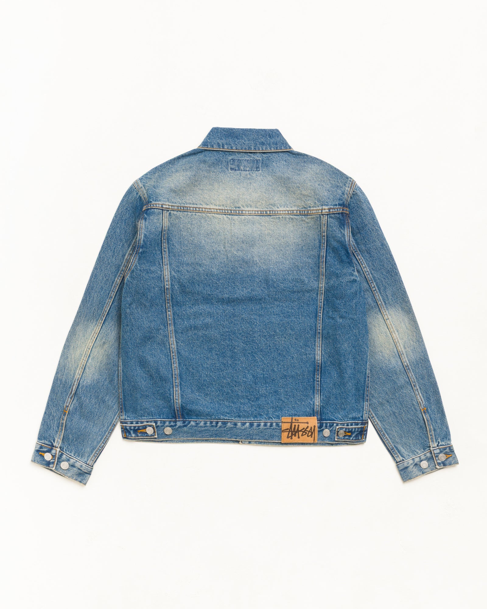 다크 워시 인디고 컬러의 데님 트러커 재킷, 뒷면 스웨이드 Stüssy 로고 패치와 버튼 디테일