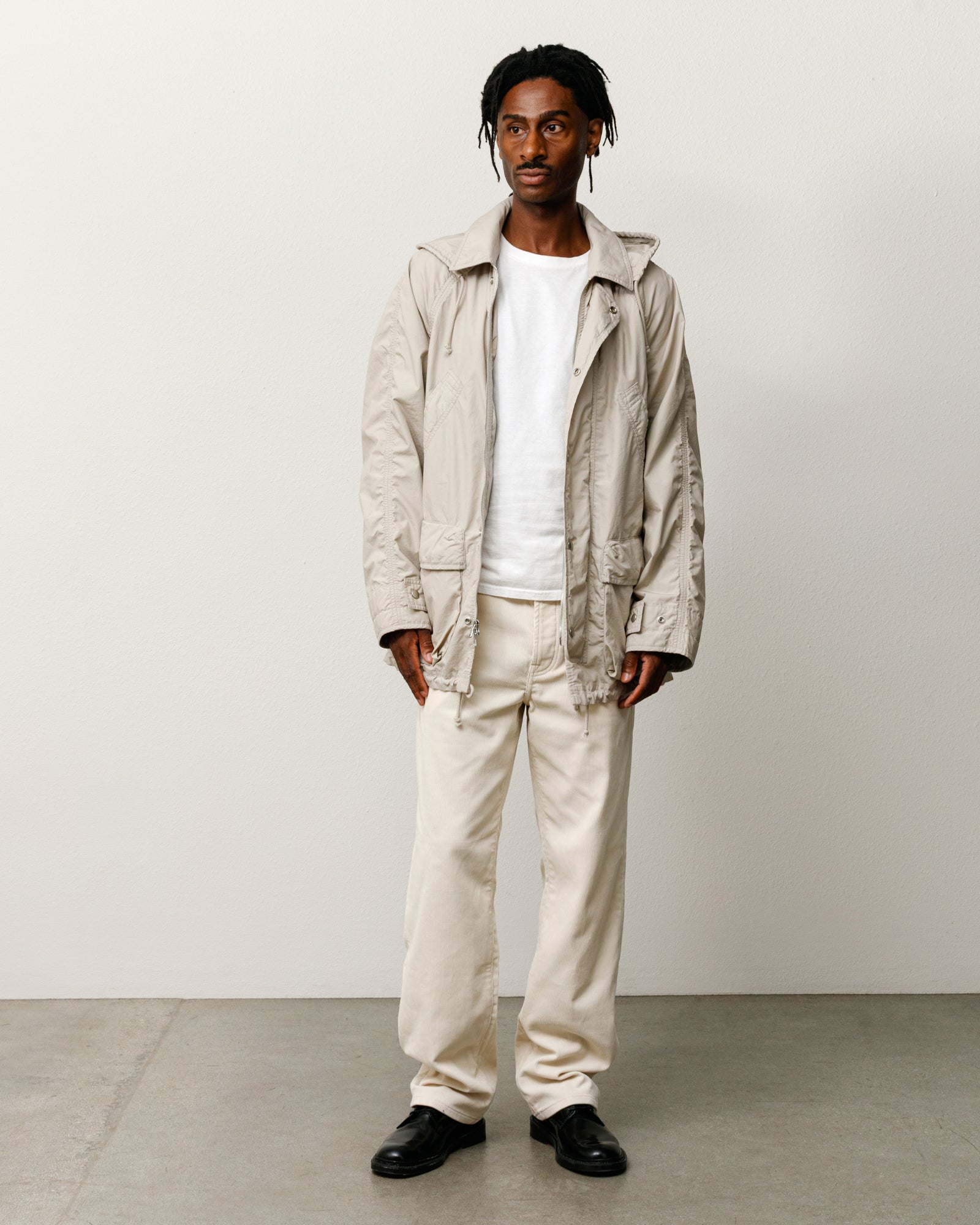 스톤 컬러의 경량 필드 파카 아우터웨어, 워시드 코튼의 여유로운 핏과 탈부착 가능한 후드 디자인.
