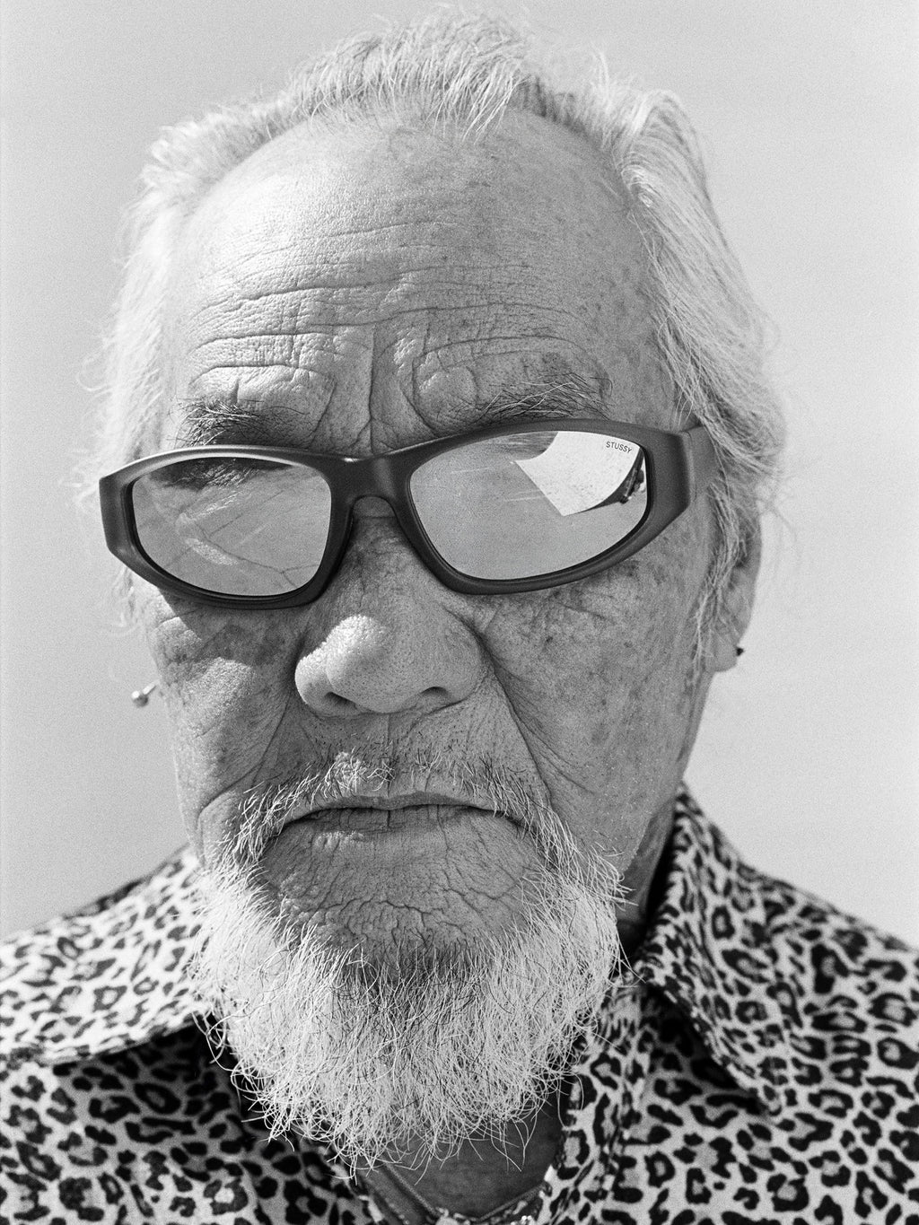 Pops wears the Leslie sunglasses in Matte Black Rubber/Blue Mirror Lens with the Animal Print Flannel Shirt in Leopard.