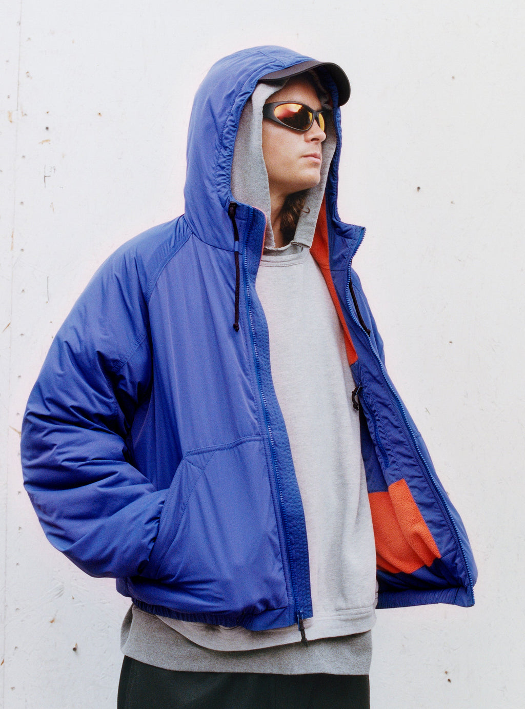A person wearing the Coastline Jacket in Iris looks off to the side.