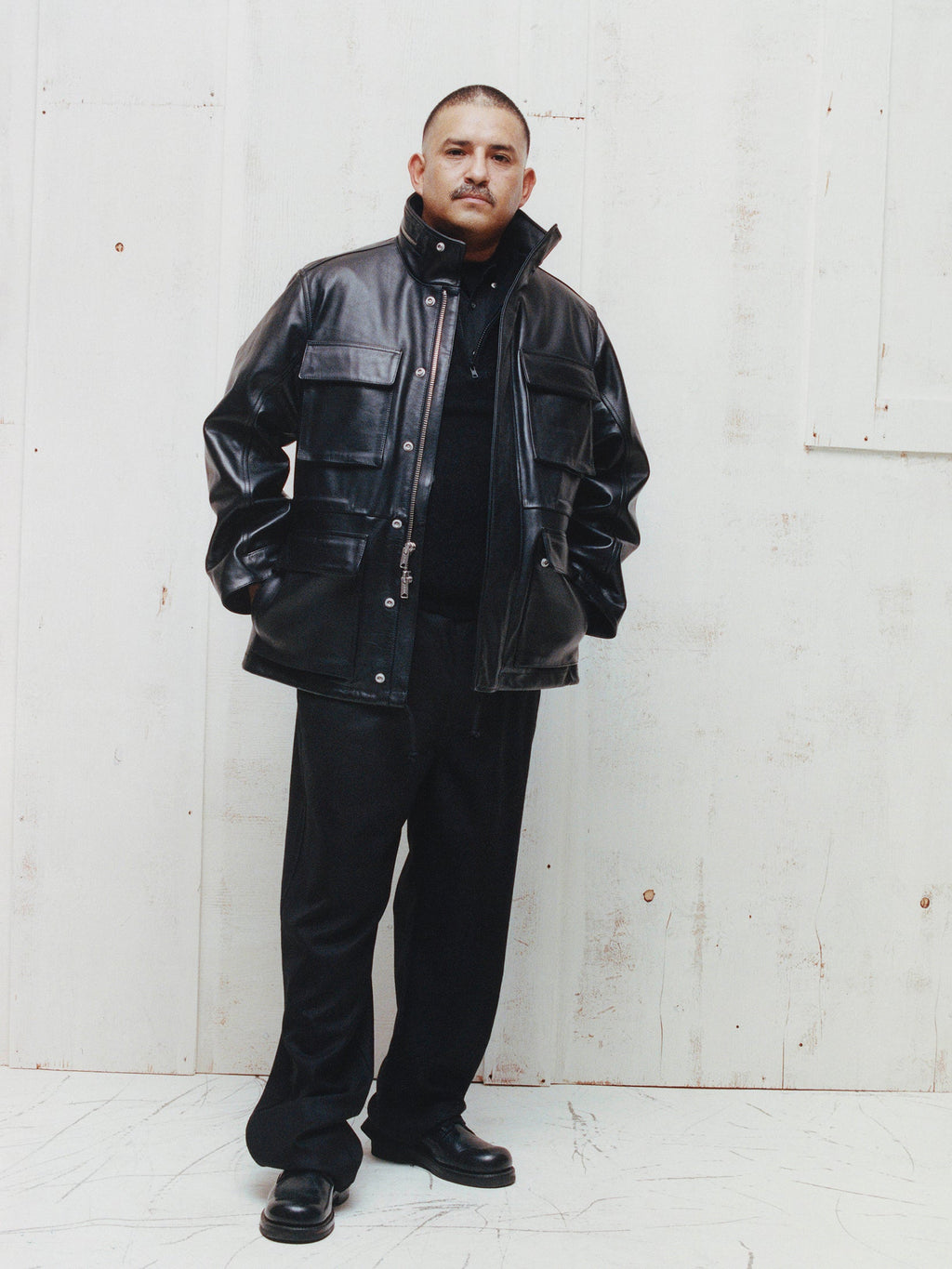 Model wears the Stüssy Leather M-65 Jacket in Black with black trousers and black boots.